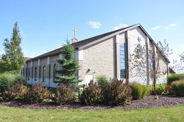 A church with a large building and some bushes