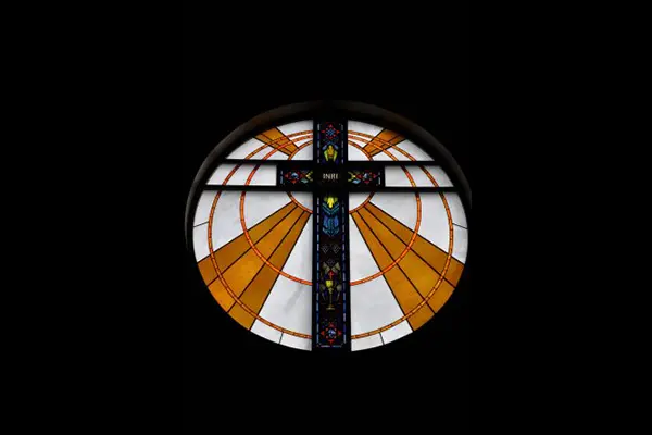 A stained glass window with the cross in it.